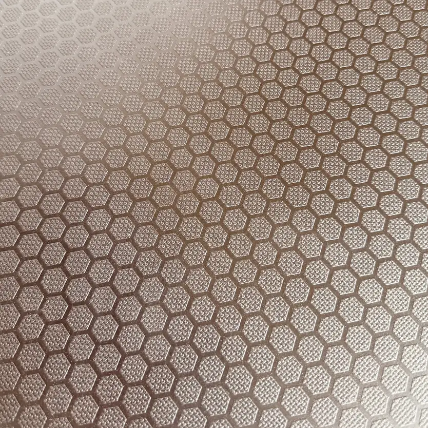 Brown anti-slip film face with a raised hexagon pattern, each cell filled with fine dot texture
