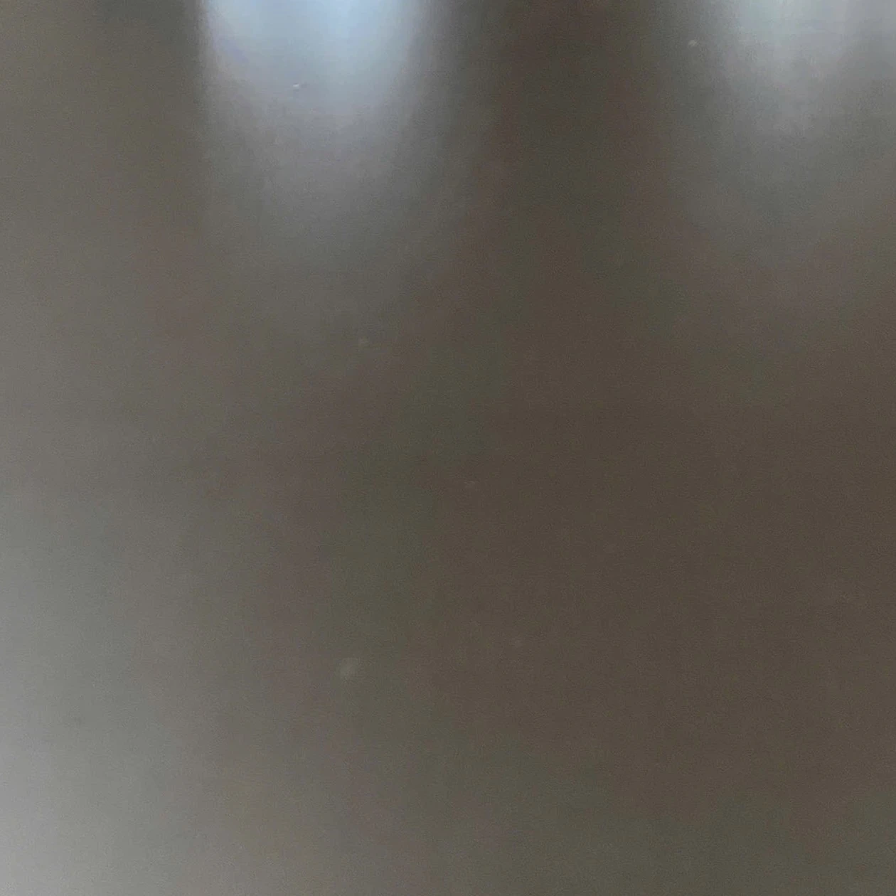 Smooth dark brown film face of a plywood panel with soft reflected light